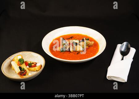 Ulaanbaatar, Mongolei. Mai 2025. Ein Teller mit frisch gekochter Meeresfrüchtesuppe wird auf eine schwarze Tischdecke gestellt. Quelle: L.Enkh-Orgil. Stockfoto