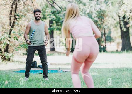 Freunde, die an einem sonnigen Tag Badmintonspiele im Park genießen Stockfoto