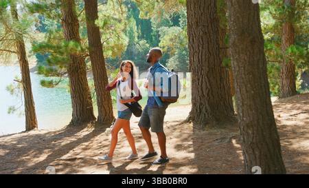 Paare Auf Einer Wanderung Durch Woods By Lake Stockfoto