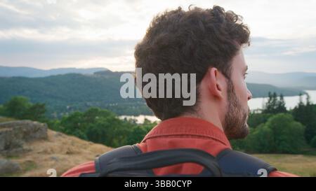 Nahaufnahme von Young man, der am Top of Hill auf einer Wanderung durch die Landschaft im Lake District UK steht Stockfoto