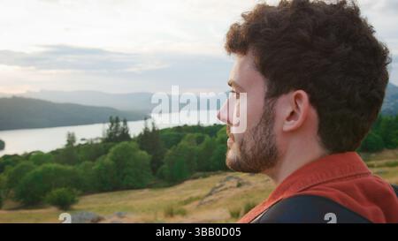 Nahaufnahme von Young man, der am Top of Hill auf einer Wanderung durch die Landschaft im Lake District UK steht Stockfoto
