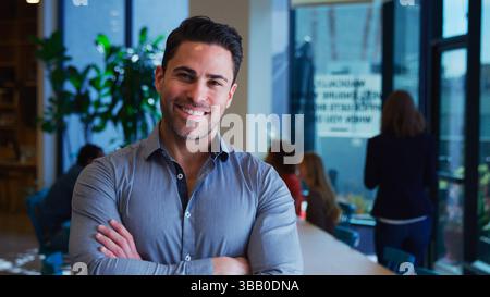 Porträt Eines Reiferen Geschäftsmannes Im Geschäftigen Modernen Büro Mit Kollegen Im Hintergrund Stockfoto