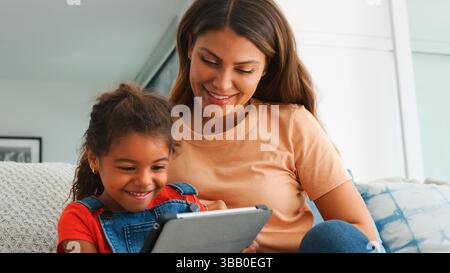 Hispanische Mutter Hilft Tochter Zur Hausschule Und Macht Hausaufgaben Mit Einem Digitalen Tablet Stockfoto
