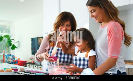 Mehrere Generationen Weibliche Hispanic-Familie, Die Spaß In Der Küche Hat, Kuchen Zusammen Zu Machen Stockfoto