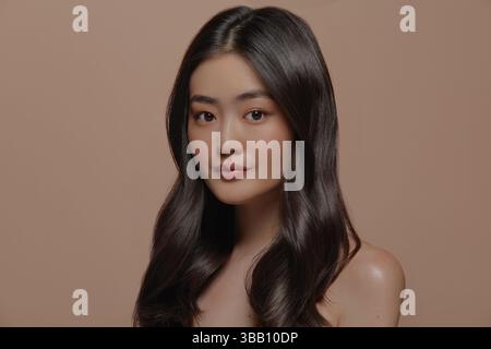 Beautiful young asian woman with clean and smooth fresh skin on beige background. Face care, Facial treatment, Cosmetology, beauty and spa, Asian Stockfoto