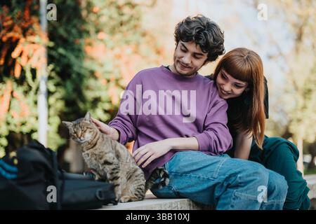 Ein junges Paar genießt die Zeit mit einer Katze im Park Stockfoto