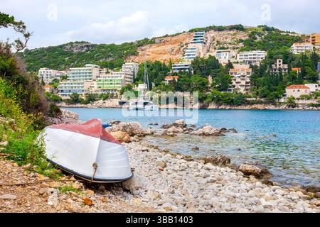 Weißes Boot ruht an den felsigen Ufern der Bucht von Lapad. Dubrovnik, Kroatien Stockfoto