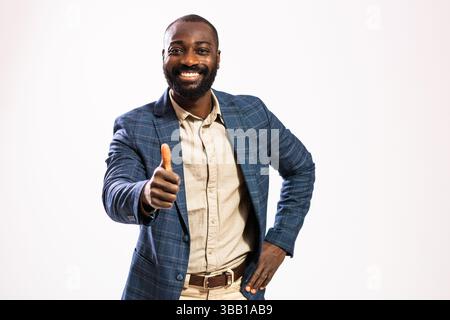 Porträt eines glücklichen und erfolgreichen Geschäftsmannes. Schwarzer Mann im Business-Anzug sieht in die Kamera und zeigt Daumen nach oben. Stockfoto