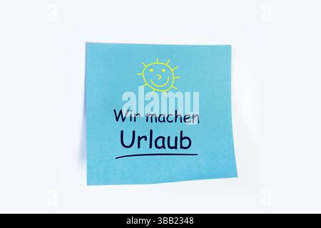 Notizblock mit hinzugefügtem Text wir MACHEN URLAUB vor weißem Hintergrund Stockfoto