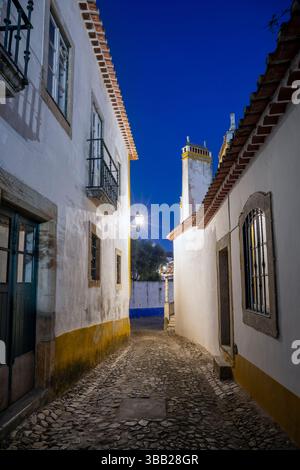 Portugal, Region Oeste, Óbidos, Rua Lourenco Marken mit traditioneller Architektur in der ummauerten Zitadelle bei Nacht Stockfoto