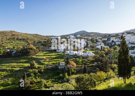 Weiße Gebäude verstreut auf einem üppigen Hügel im idyllischen Dorf Lefkes auf der Insel Paros in Griechenland unter einem klaren blauen Himmel an einem sonnigen Tag. Stockfoto