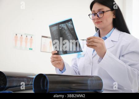 Arzt untersucht Hals-MRT am Tisch in der Klinik, Tiefwinkelansicht Stockfoto