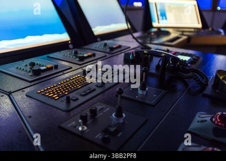 Schifffahrtssimulator. Ein moderner Kontrollraum mit beleuchteten Konsolen, Joysticks, Kommunikationsgeräten und digitalen Bildschirmen, illustriert Stockfoto
