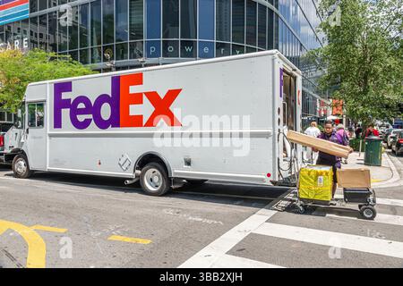 Miami Florida, Brickell Financial District, South Miami Avenue, FedEx Lieferwagen auf der Straße geparkt, Mitarbeiter entladen Pakete von hinten, Handwagen mit Stockfoto