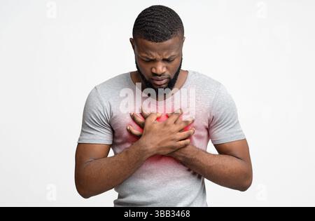 Trauriger junger Mann mit akuten Schmerzen in der Brust Stockfoto