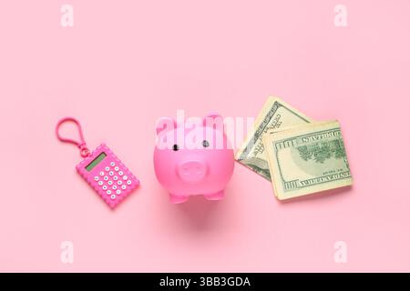 Schweinebank mit Dollarscheine und Taschenrechner auf rosa Hintergrund Stockfoto