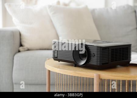 Moderner Projektor auf Holztisch im Zimmer, Nahaufnahme Stockfoto