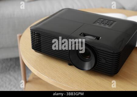 Moderner Projektor auf Holztisch im Zimmer, Nahaufnahme Stockfoto