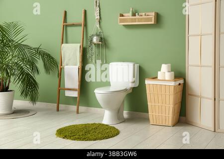 Das Innere des stilvollen Toiletten mit Keramikschale, Papierrollen und Korb Stockfoto