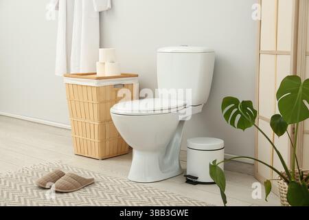 Das Innere des stilvollen Toiletten mit Keramikschale, Mülleimer und Korb Stockfoto