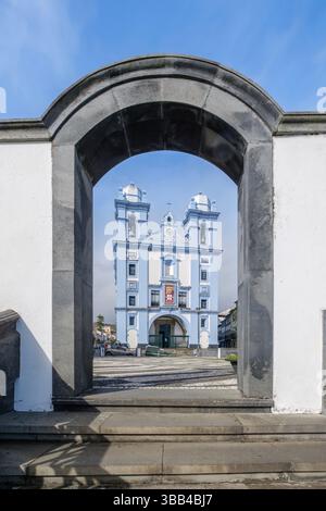 Igreja da Misericordia wurde durch einen Steinbogen auf den Azoren eingerahmt. Atemberaubende blau-weiße portugiesische Kolonialkirche mit zwei Glockentürmen in Terceira IS Stockfoto