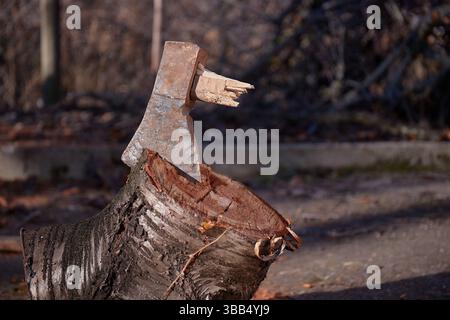 Gebrochene Axt steckt in einem Holzblock fest Stockfoto