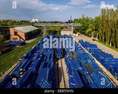Stapel von Gusseisenrohren im Ladebereich, Warten auf Transport, Drohnenansicht. Stockfoto