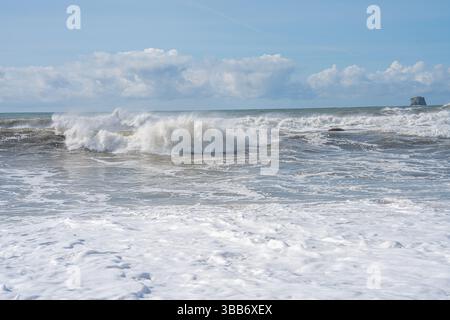 Schaumige Wellen krachen und Rollen im Pazifik unter einem hellblauen Himmel. Stockfoto