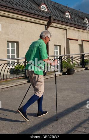Senior Mann, der die Straße entlang läuft Stockfoto