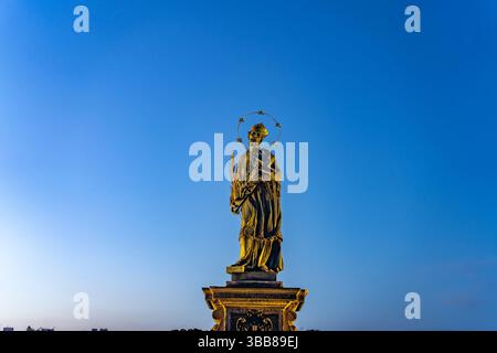Der Brückenheilige Johannes Nepomuk auf der Karlsbrücke in der Abenddämmerung, Prag, Tschechische Republik | Brücke Johannes von Nepomuk auf Karl Stockfoto