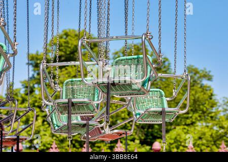 Farbenfrohe Schaukelkarouselstühle Vor Dem Blauen Himmel – Hintergrund Der Vergnügungspark-Fahrt Stockfoto