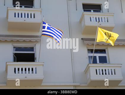 Griechische Nationalflagge und griechisch-orthodoxe Kirchenflagge mit Kreuzflug in der Luft in Thessaloniki, Griechenland Stockfoto
