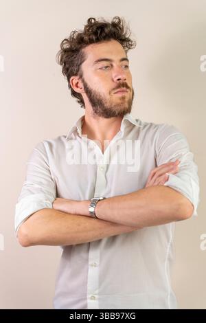 Vertikales Studio-Porträt eines selbstbewussten Geschäftsmannes der Generation Y in weißem Hemd, der nach oben blickt und Ehrgeiz, Vision und zukünftigen Erfolg auf Neutr symbolisiert Stockfoto