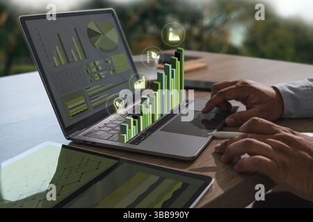 Ein Bild für nachhaltige Geschäftspraktiken zeigt Personen, die mit einem Notebook arbeiten, mit digitalen Diagrammen und Diagrammen, die Datenanalyse und Wachstum anzeigen Stockfoto