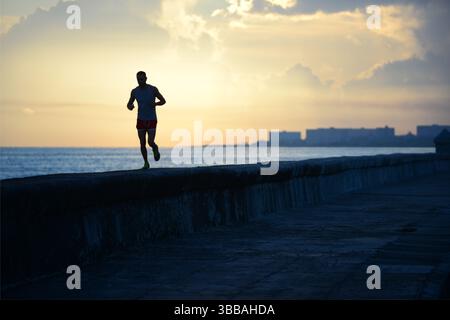 Ein Mann, der entlang des Karibischen Meeres in Havanna, Kuba, läuft Stockfoto