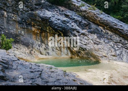Türkisfarbene Naturschwimmbäder aus Kalkstein. Smaragdklares Wasser, das durch felsiges Flussbett fließt, schafft perfekte Badeplätze in wilder Natur Stockfoto
