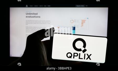 Stuttgart, Deutschland - 27.12.2024: Person, die ein Mobiltelefon mit dem Logo des deutschen Wealth Management Software Unternehmens QPLIX GmbH auf dem Bildschirm hält Stockfoto