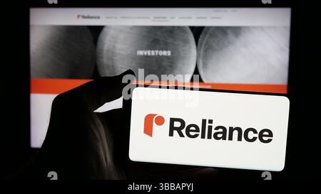 Stuttgart, Deutschland, 27.12.2024: Person, die ein Mobiltelefon mit dem Logo des amerikanischen Metallverarbeitungsunternehmens Reliance Inc. Auf dem Bildschirm hält Stockfoto