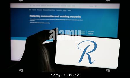 Stuttgart, Deutschland - 27.12.2024: Person, die ein Mobiltelefon mit dem Logo der Rückversicherungsgesellschaft RenaissanceRe Holdings Ltd. Auf dem Bildschirm hält Stockfoto