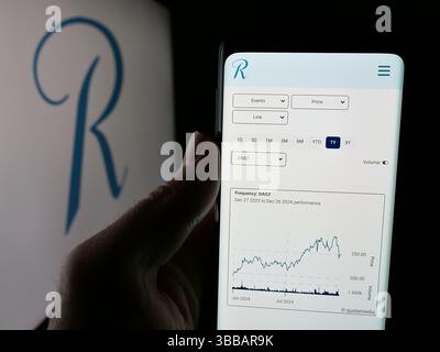 Stuttgart, Deutschland - 27.12.2024: Person, die ein Mobiltelefon hält, mit Webseite der Rückversicherungsgesellschaft RenaissanceRe Holdings Ltd. Auf dem Bildschirm mit Logo. Stockfoto