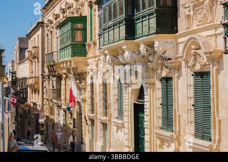 Barocke Straße Valletta, Blick auf eine Straße gesäumt von typisch maltesischen Barockgebäuden mit geschlossenen Holzbalkonen, Valletta, Malta Stockfoto