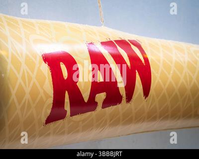 Brig, Schweiz - 8. Mai 2025: Eine Nahaufnahme eines gelben Banners mit dem Wort RAW in fettgedruckten roten Buchstaben. Der Hintergrund ist hell bl Stockfoto