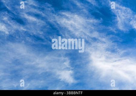 Hellblauer Himmel im Hintergrund mit hellweißen Wolken im Vordergrund. Stockfoto