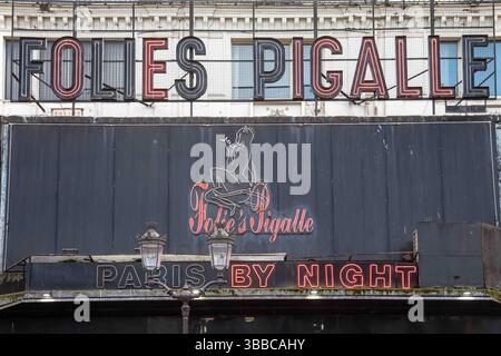 Folies Pigalle, Paris bei Nacht. Verwittertes, teilweise gearbeitetes Neonschild an der grungy-Fassade des berühmten Nachtclubs Montmartre in Paris, Frankreich. Stockfoto