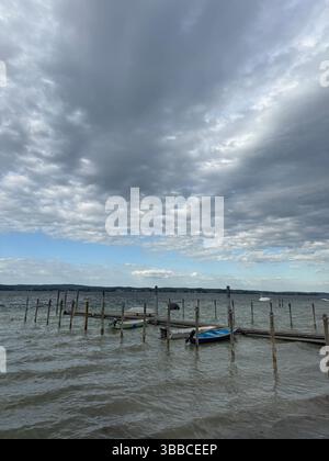 Dramatische Wolkenstimmung über dem Untersee bei Berlingen im Kanton Thurgau. Kleine Boote liegt ruhig am Steg, während eine Sturmwarnung über dem SE Stockfoto