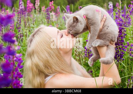 moskau, russland, 13.07.2017 Eine Frau hält eine Katze und küsst sie. Die Katze ist grau und die Frau ist blond. Die Szene ist glücklich und liebevoll Stockfoto