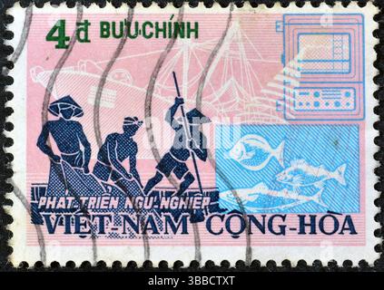 Von Südvietnam gedruckte Briefmarke, die Fischer im Boot zeigt, und einen modernen Trawler, Fishing Industry, um 1972. Stockfoto