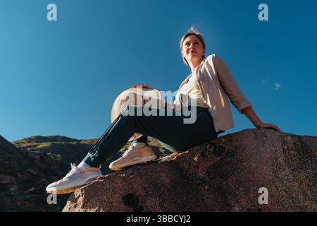 Eine junge Wanderer, die auf dem Berg sitzt Stockfoto