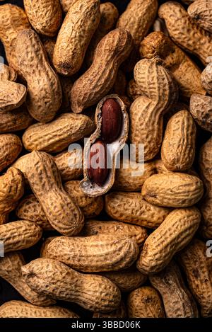 Erdnussstapel mit einer offenen Schale Stockfoto