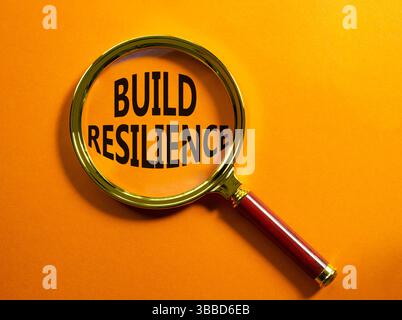 Symbol für Belastbarkeit erstellen. Vergrößerungsglas mit Wörtern erhöht die Widerstandsfähigkeit. Wunderschöner orangefarbener Hintergrund. Business- und Build Resilience-Konzept. Kopierbereich. Stockfoto